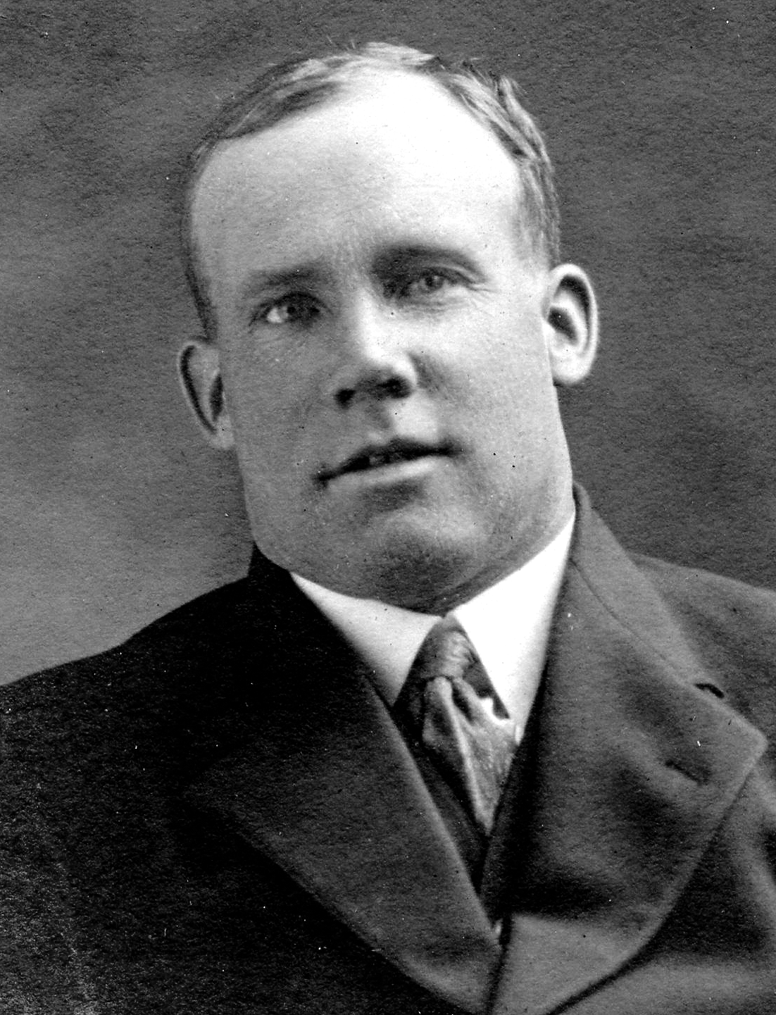 Black and white archival photograph of a man in a suit and tie.