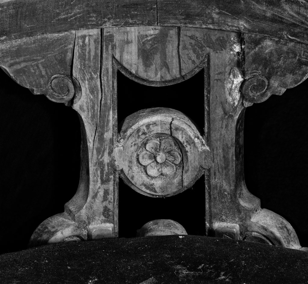 Black and white modern photograph of wooden saloon chair detail.