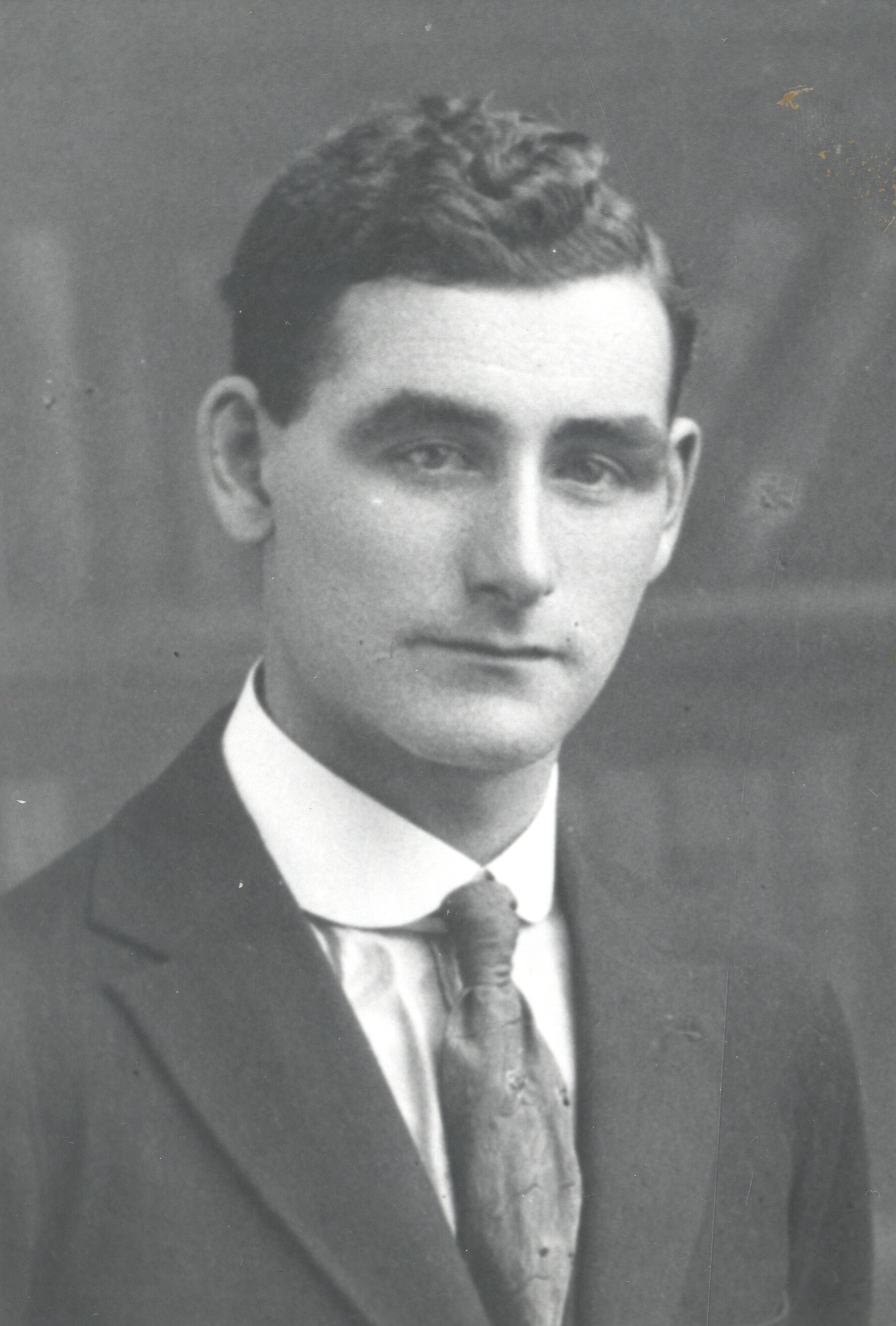 Black and white archival photograph of a man in a suit and tie.