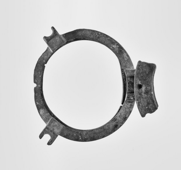 Black and white modern photograph of porthole. Metal circle with hinge to the right hand side.