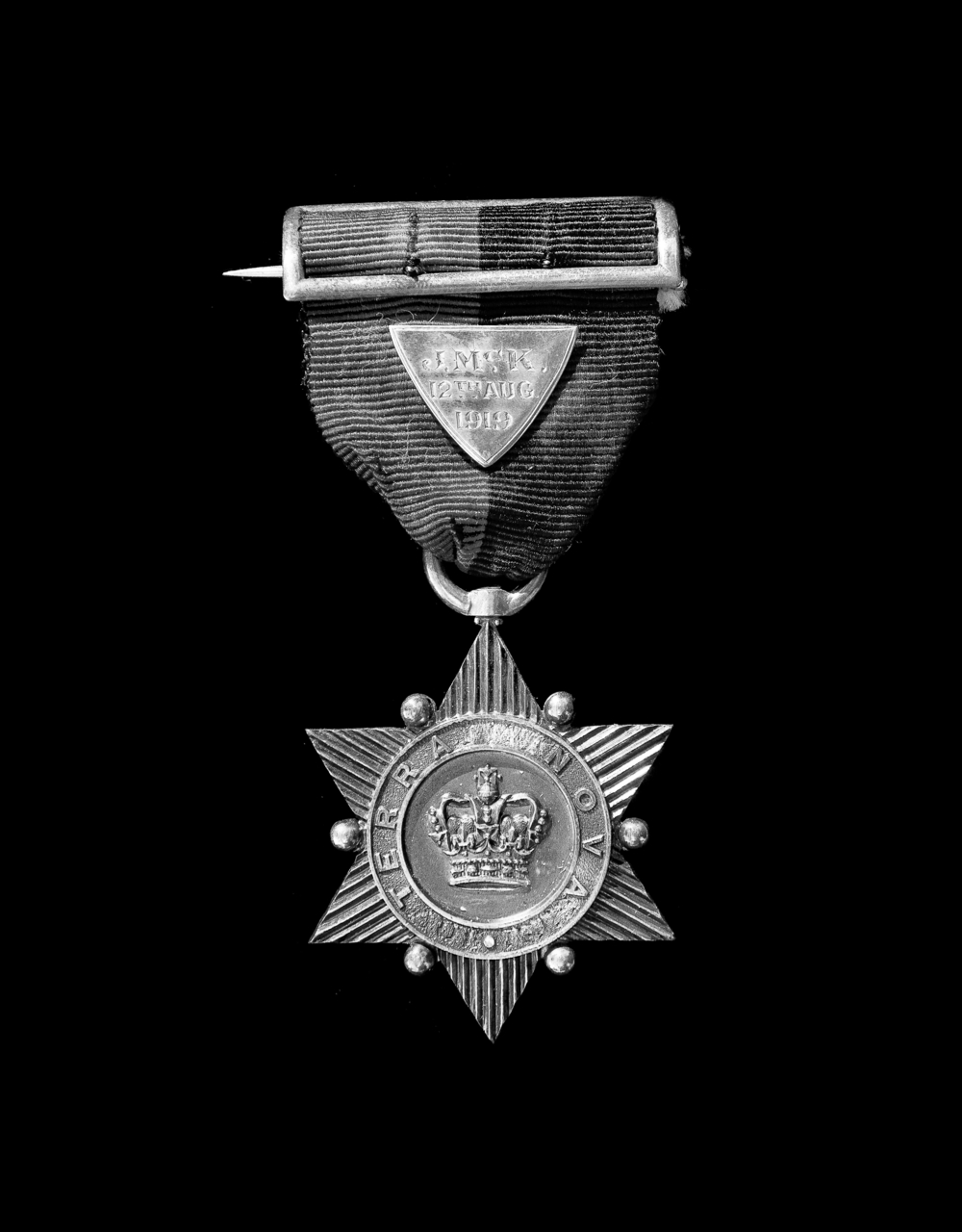 Photographie moderne en noir et blanc d’une médaille sur un ruban.