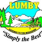 Un emblème a des montagnes et un lac. Au premier plan on voit des arbres et des tiges de maïs. Sur l’emblème c’est écrit : Lumby, la porte aux Monashees, simplement le meilleur.