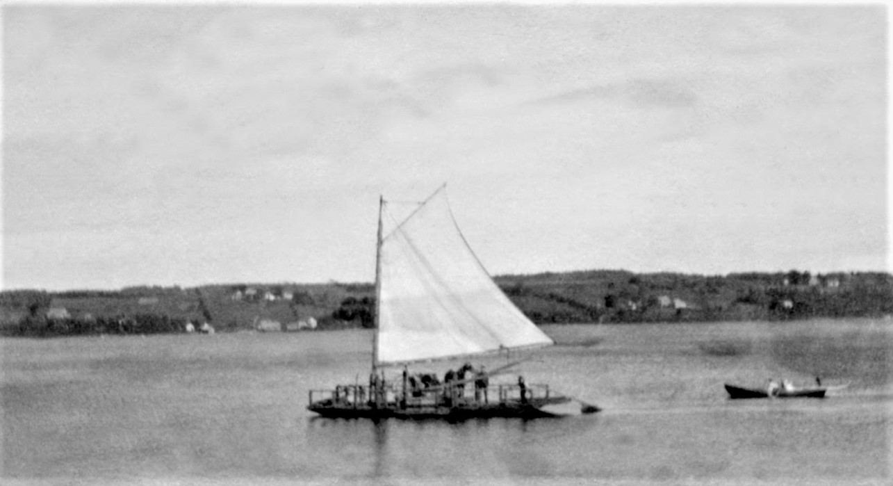 A sailing ferry transporting two men and a horse-drawn carriage across a river.