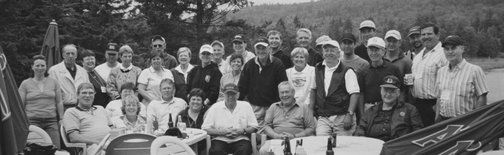 Group photo of twenty-one men and twelve women on a golf clubhouse deck.