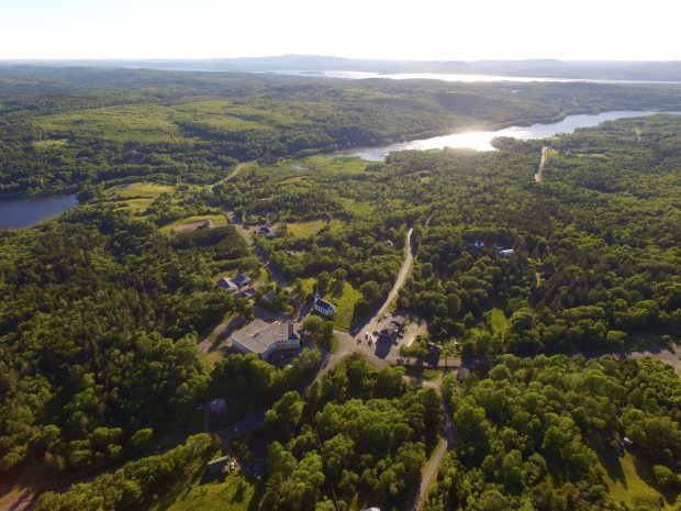 Aerial view of treed rolling hills and 3 bodies of water.