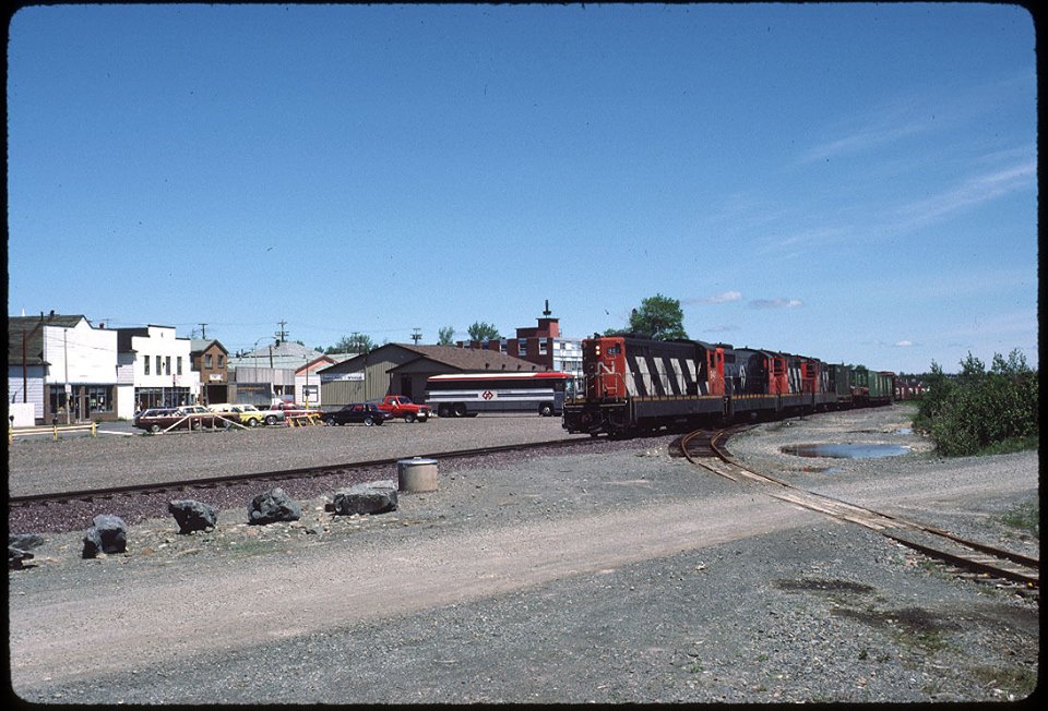 Colour photograph. Photo looking towards Main Street from behind railway tracks. CN train on right side and train station in the centre of the photo.