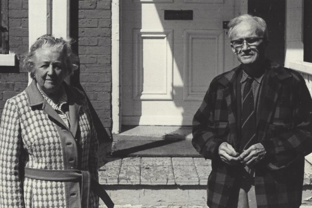 Black-and-white photograph of a man and a woman standing outside Manoir Fraser.