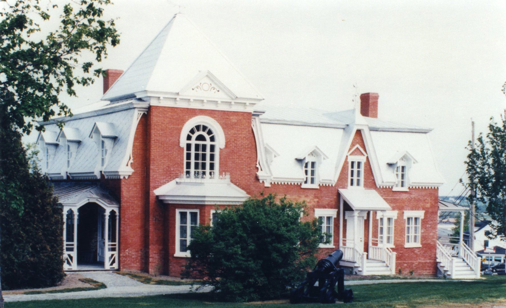 Colour photograph. Façade of a brick house in close-up.