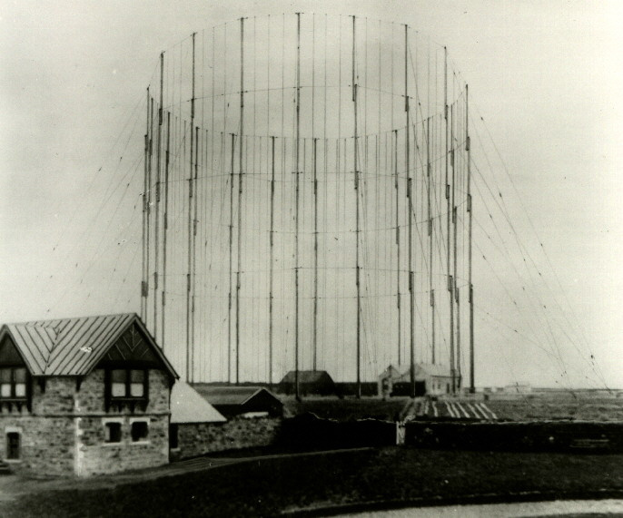 A circle of aerial towers and support wires surrounds a single-storey building.