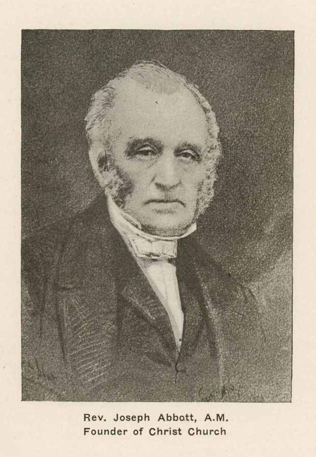 Black and white portrait of an elderly Reverend Joseph Abbott, head and shoulders. He has short hair and grey and white sideburns, and is looking at the camera with a serious expression. He is wearing a black minister’s robe and a white collar. The background is black. The inscription under the portrait reads “Rev. Joseph Abbott, A.M. Founder of Christ Church”.