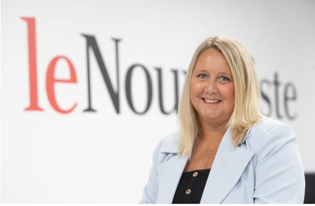 Colour photograph of Julie Michaud against a backdrop consisting of the Le Nouvelliste masthead.