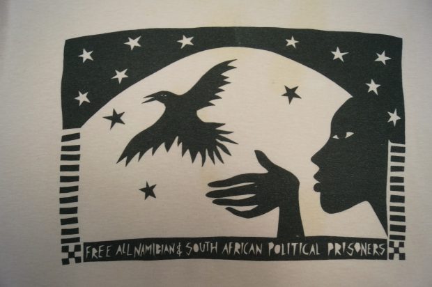 Eine Decke mit einer Frau, die einen Vogel freilässt, besagt: „Free All Namibian and South African Political Prisoners“ (Befreit alle namibischen und südafrikanischen politischen Gefangenen).