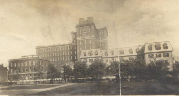 Sepia-toned photograph showing a 19th C hospital building with a more contemporary extension behind it.