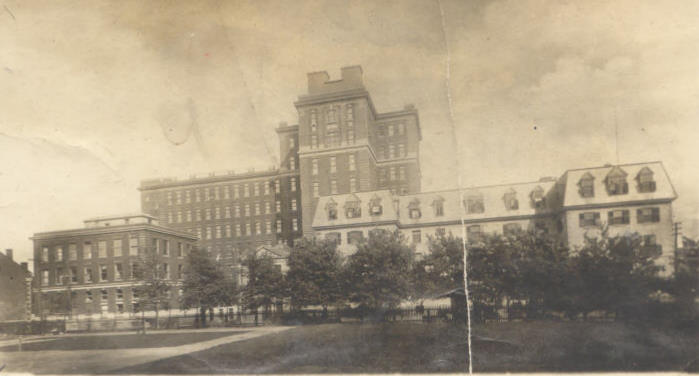 Sepia-toned photograph showing a 19th C hospital building with a more contemporary extension behind it.