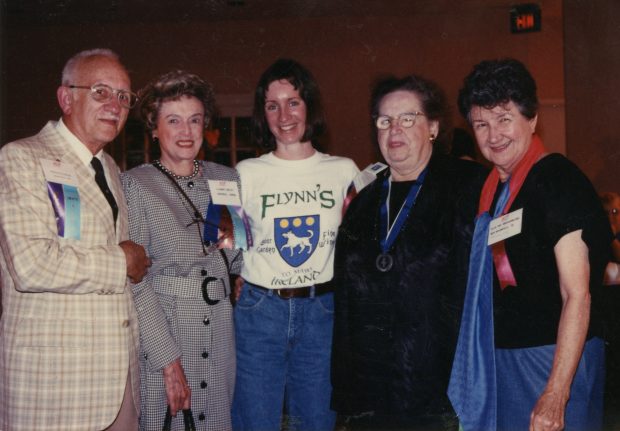 Colour photo of 5 people, shoulder to shoulder, wearing ribbons and medals.