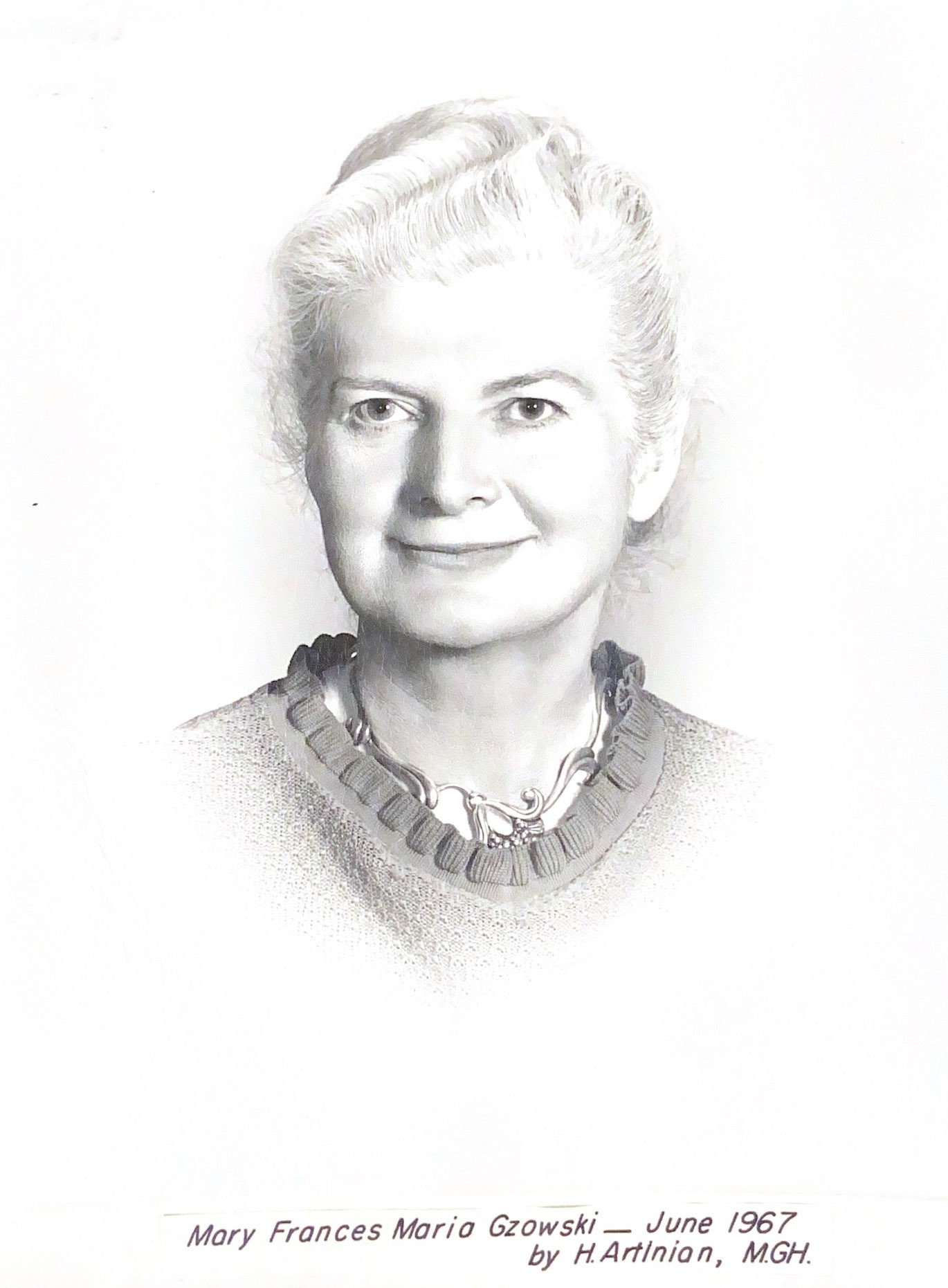 Black and white portrait of a woman wearing a sweater, a necklace and well coiffed white hair.