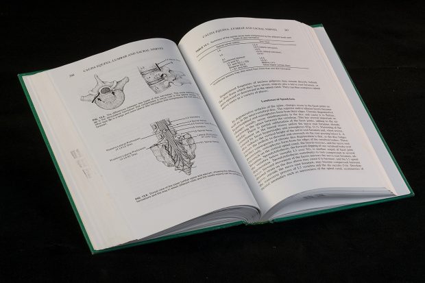Colour photo of an open book containing medical illustrations and text.