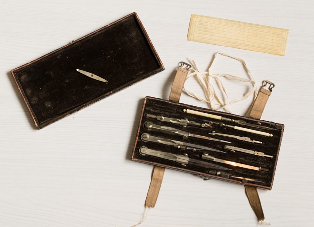 Colour photograph showing an open case with a dark, felted interior containing small metal and bone tools.