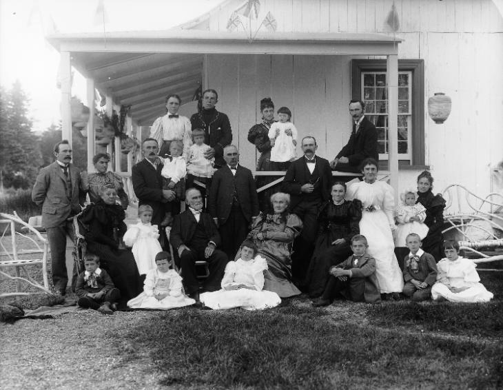 Black and white photograph of twenty-six members of the Mathewson family gathered at their home in Little Metis for a special event. In the center of the group are Mr. and Mrs. Mathewson.