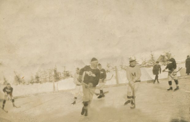 Sephia image of five young hockey players on an outdoor skating rink in Metis.