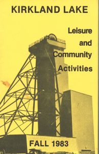 Colour scan of a yellow pamphlet cover, titled Kirkland Lake: Leisure and Community Activities - Fall 1983. Background image is of the Macassa #3 headframe.