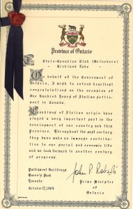 Certificate with Ontario provincial crest at top centre, a dark blue ribbon and a red melted wax seal in upper left corner. Signature of Premier of Ontario in lower right corner.