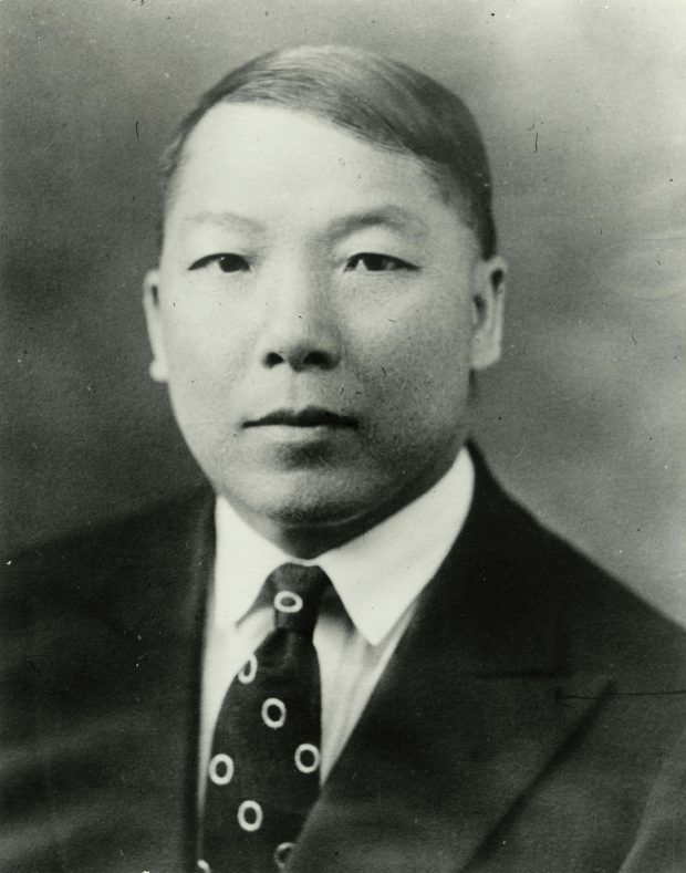 Black and white portrait photograph of Charlie Chow as a young man wearing a suit and tie.