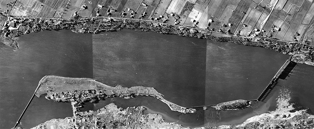 Black and white aerial photographs of La Visitation Island in 1947. The mills are on the left, on the dike between the islands of Montreal and La Visitation. The Des Prairies River hydroelectric power plant is on the right, between La Visitation Island and Île Jésus (Laval).