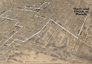 Carte illustrée d’Hamilton montrant la baie de Burlington au sud et le parc Victoria à l’est. La carte inclut une nouvelle illustration de l’itinéraire circulaire du défilé de la Ligue des neuf heures, commençant et se terminant dans l’est.