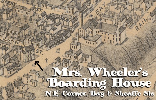 An illustrated map shows part of the city of Hamilton in the mid-1800s. Illustrated houses and other structures fill the map leading to a sloped hill on the right side of the image. A three-storey building at the North-East corner of Bay and Sheaffe Streets is identified as Mrs. Wheeler’s Boarding House.