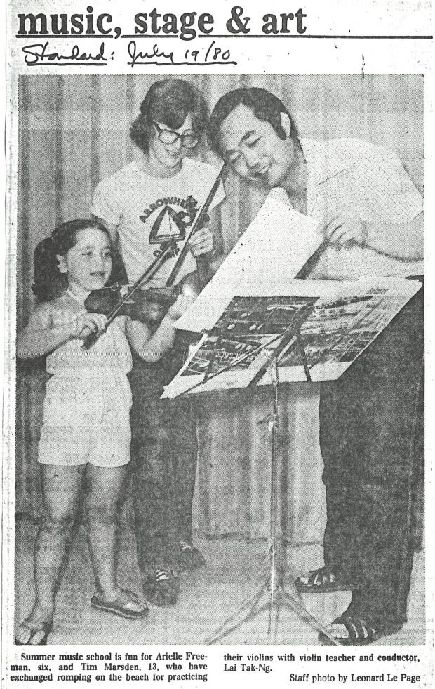 Conductor and two students look at music on stand