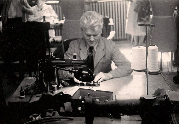 Man seated at sewing machine