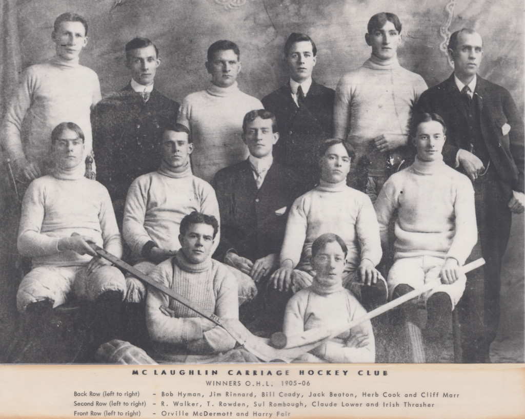 Image en noir et blanc représentant neuf joueurs de hockey et quatre entraîneurs en tenue formelle. Sept d’entre eux sont assis, les six autres sont debout. Titre : JOUEURS DU MCLAUGHLIN CARRIAGE HOCKEY CLUB, VAINQUEURS O.H.L. 1905-1906.