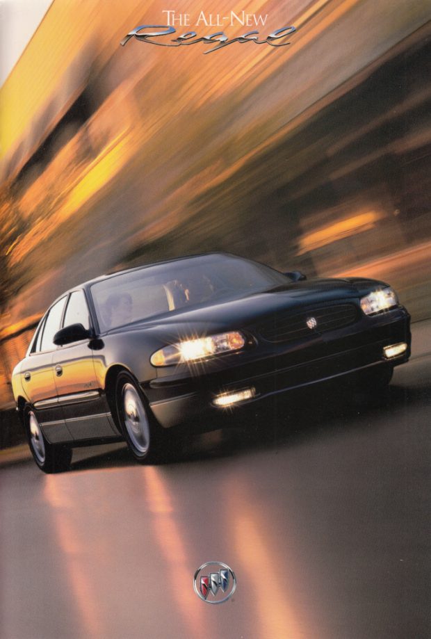 Advertising image of a car with its headlights on driving through a blurry cityscape. Title text reads The All-New Regal