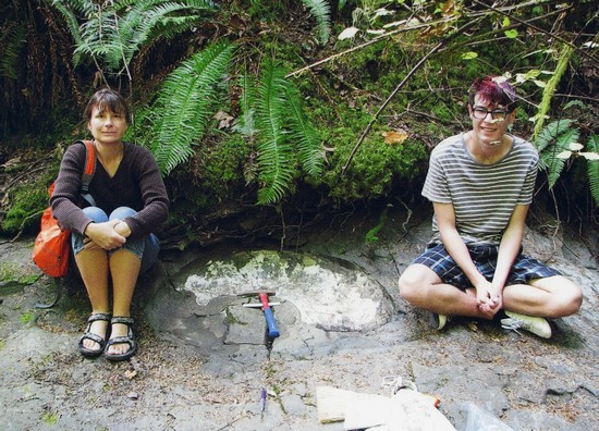 Elke and Enzo Wohlleben sitting on either side of the newly-discovered ammonite fossil.