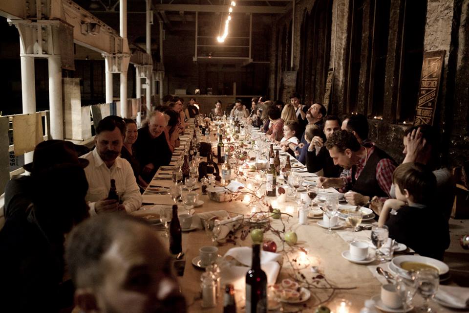 People dining at a long table upstairs at the Machine Shop