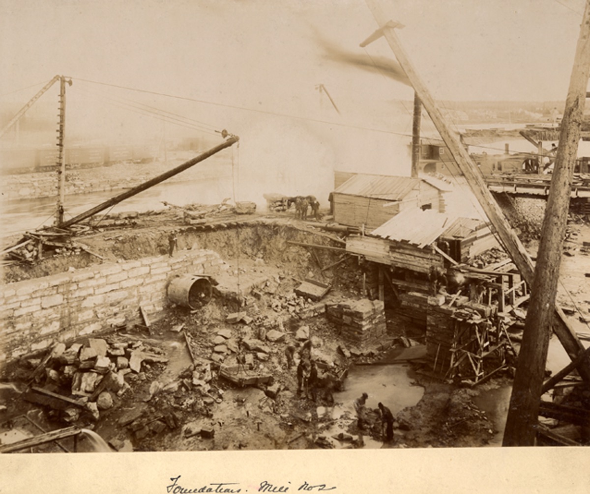 Le chantier de construction du moulin No 2 avec ses murs de pierre, les grues et les amoncellements de débris.