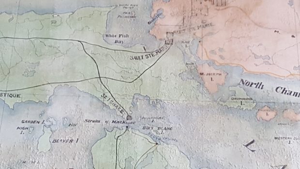 Close up of a hand painted map. Sault Ste. Marie and the Great Lakes and the North Channel are visible. Black lines represent railroads, squares represent shipping centres.