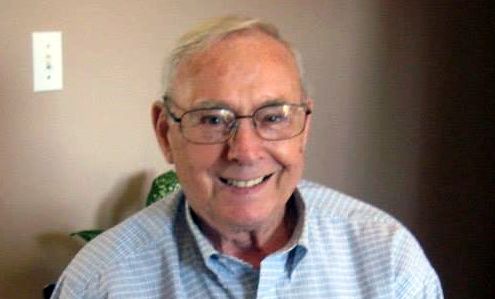 Headshot of retired paper mill worker wearing thin-rimmed glasses and a button-up shirt.