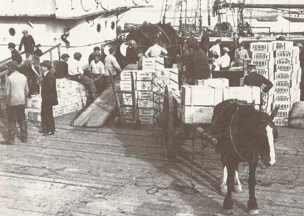 Des hommes déchargent des caisses sur un bateau
