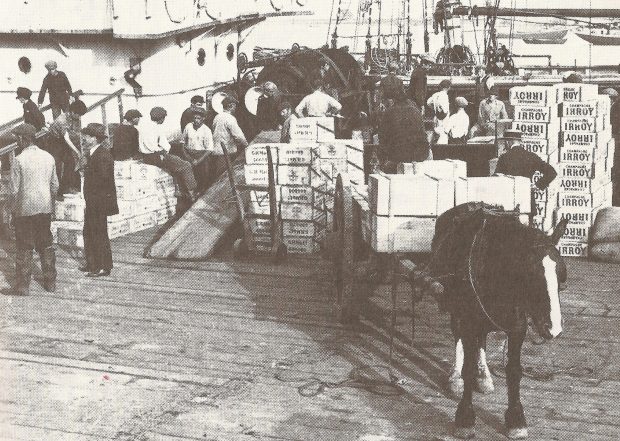 Men unload boxes onto a boat