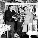 Police officers examining cans during a raid.