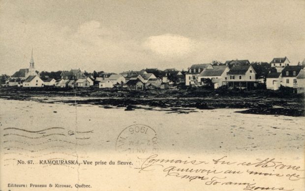 Sepia postcard No. 87. KAMOURASKA. – View from the river (panoramic view of a small coastal town). Foreground: expanse of water (St. Lawrence River). Shore: houses, church with a pointed steeple. Handwritten inscriptions in French. Stamp 1906. Bottom left: Publishers: Pruneau & Kirouac, Quebec.