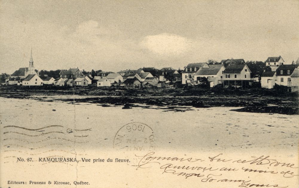 Sepia postcard "No. 87. KAMOURASKA. – View from the river" (panoramic view of a small coastal town). Foreground: expanse of water (St. Lawrence River). Shore: houses, church with a pointed steeple. Handwritten inscriptions in French. Stamp "1906". Bottom left: "Publishers: Pruneau & Kirouac, Quebec."
