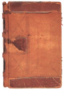 An image of Robert M. Rylatt’s original leather bound journal that is a rust orange colour. The cover has multiple tears and has some small dark stains on it.