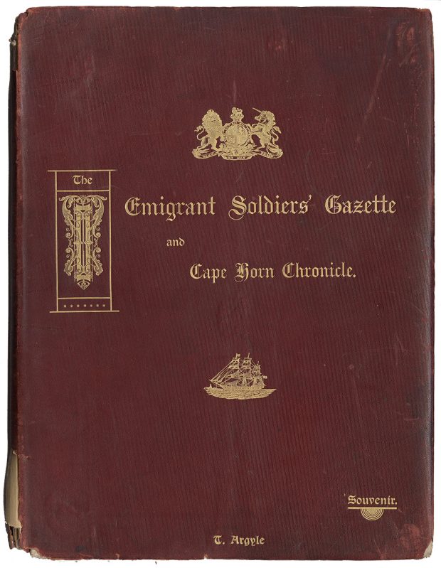 The front cover of a 1907 souvenir edition of The Emigrant Soldiers’ Gazette and Cape Horn Chronicle. The cover is burgundy with gold embossed text and images of a ship sailing on water, and the coat of arms of the United Kingdom that contains a lion and a unicorn.
