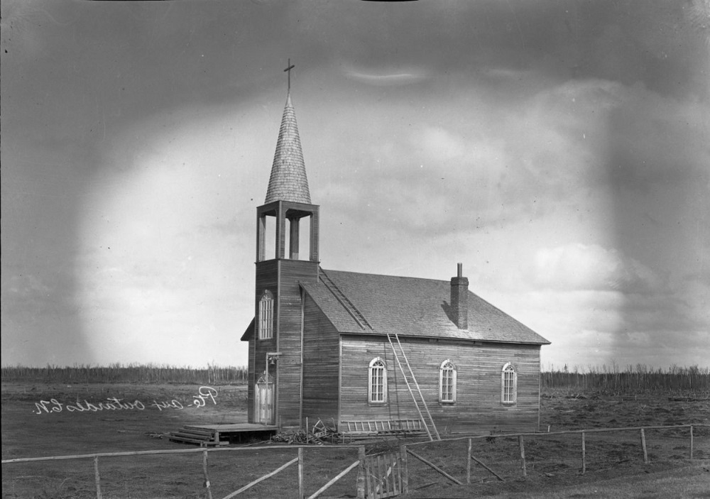 Black and white photo of a wooden church in a plain.