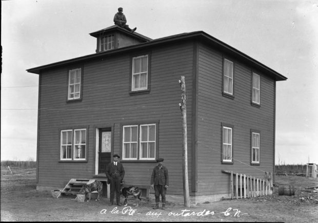 wooden house with three men and two dogs