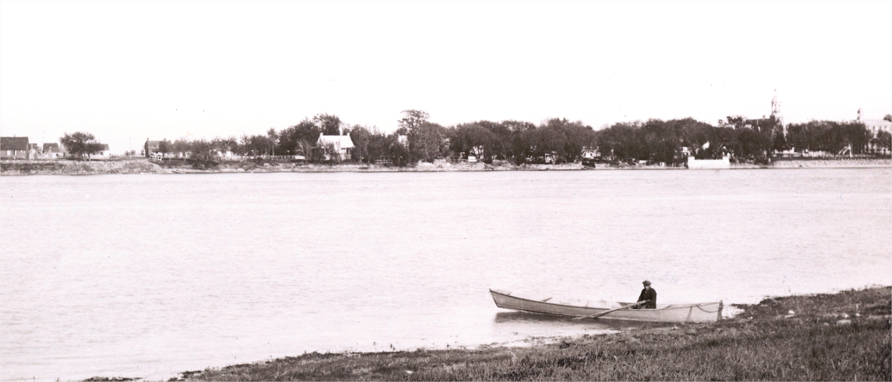 Un homme en chaloupe avec des maisons en arrière plan