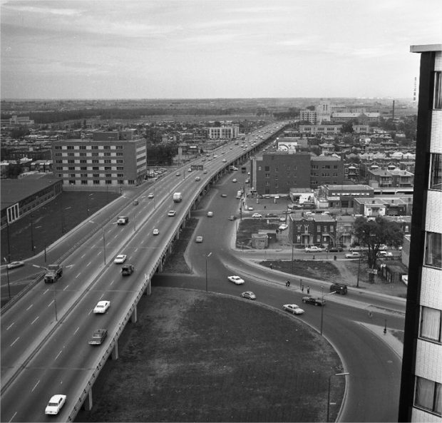 An elevated highway with a densely populated city